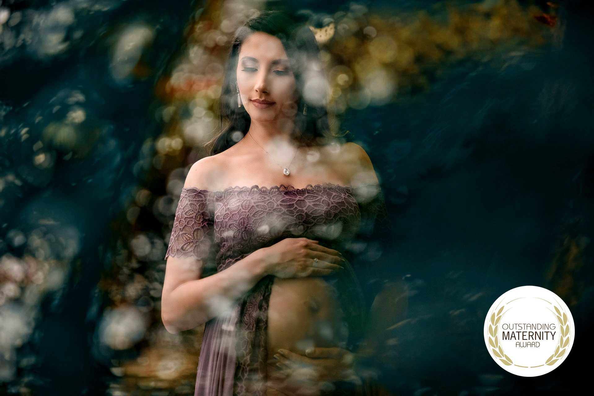 Imagem artística de uma gestante com sorriso sereno, vestindo vestido roxo com renda, em cenário natural com luz suave e efeitos de bokeh, simbolizando maternidade e esperança