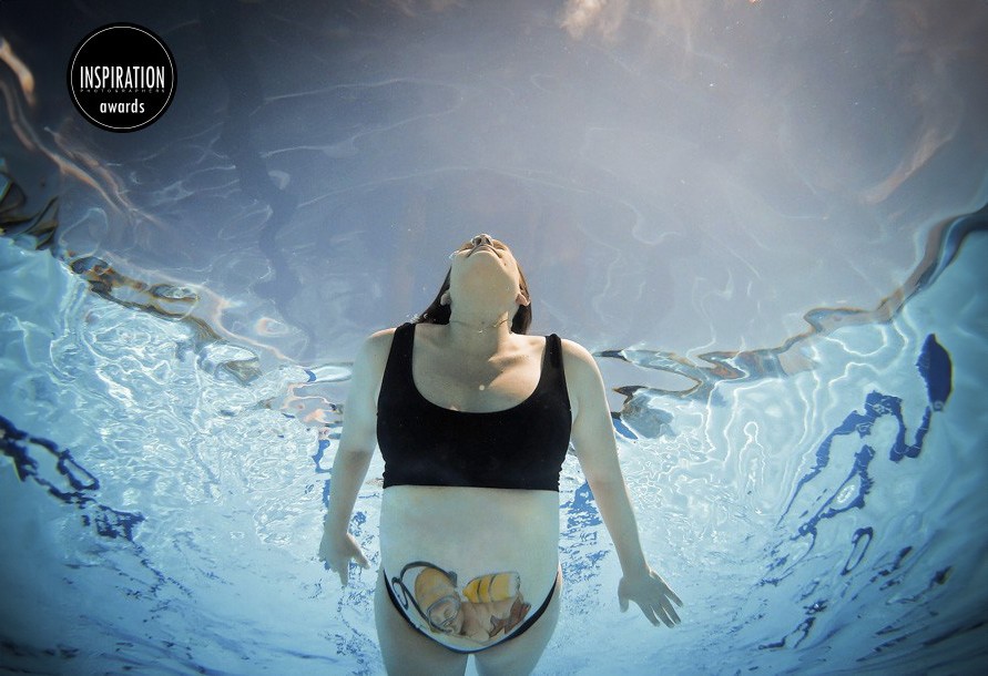 Mulher de maiô preto flutuando na piscina com câmera debaixo d'água, símbolo de inspiração e liberdade, ideal para reflexão e bem-estar